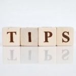 Wooden blocks spelling "TIPS" on a smooth surface, showcasing plumbing maintenance advice for homeowners.