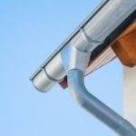 Clean metal gutter system with downspout installed, showcasing proper maintenance by Zing Plumbing in Tucson, AZ.