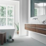 Modern bathroom with a sleek bathtub, sink, and large mirror, showcasing Zing Plumbing's fixture upgrade ideas.