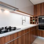 Modern kitchen with gas cooktop and wooden cabinetry, featuring stylish plumbing fixtures by Zing Plumbing.