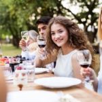 People dining outdoors with wine at an elegant table, reflecting Zing Plumbing's summer kitchen maintenance focus.