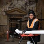 Woman in safety gear at a construction site with blueprints, representing Zing Plumbing and Adrienne Bennett's achievements.