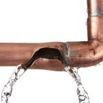 Damaged copper pipe with visible water leakage, highlighting urgent plumbing repair needs by Zing Plumbing.