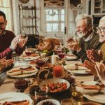 Group of five people and a dog at a dining table with food, highlighting family celebrations and potential plumbing concerns.