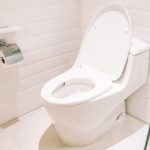 Modern toilet in a clean bathroom setting, illustrating proper toilet maintenance and hygiene related to preventing sewer line clogs.